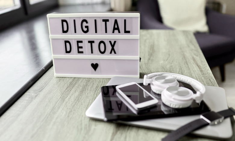 "Digital Detox" sign with electronic devices on a table.