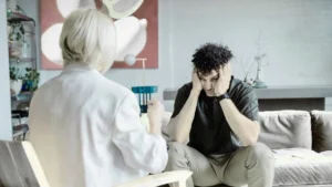 A distressed man in a therapy session expressing emotions to a counselor, symbolizing the role of therapy in emotional release.