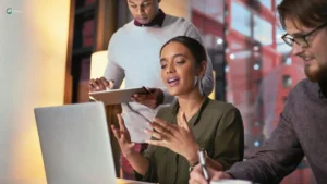 Young professionals multitasking during a meeting, highlighting how constant digital distractions impact focus at work
