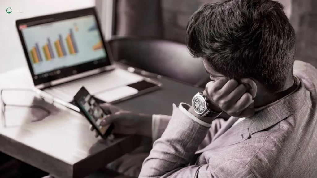 Man distracted by phone while working – the psychology behind procrastination