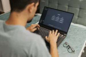 Person using an AI chatbot on laptop – concept of AI Chatbots vs Therapists in mental health support.